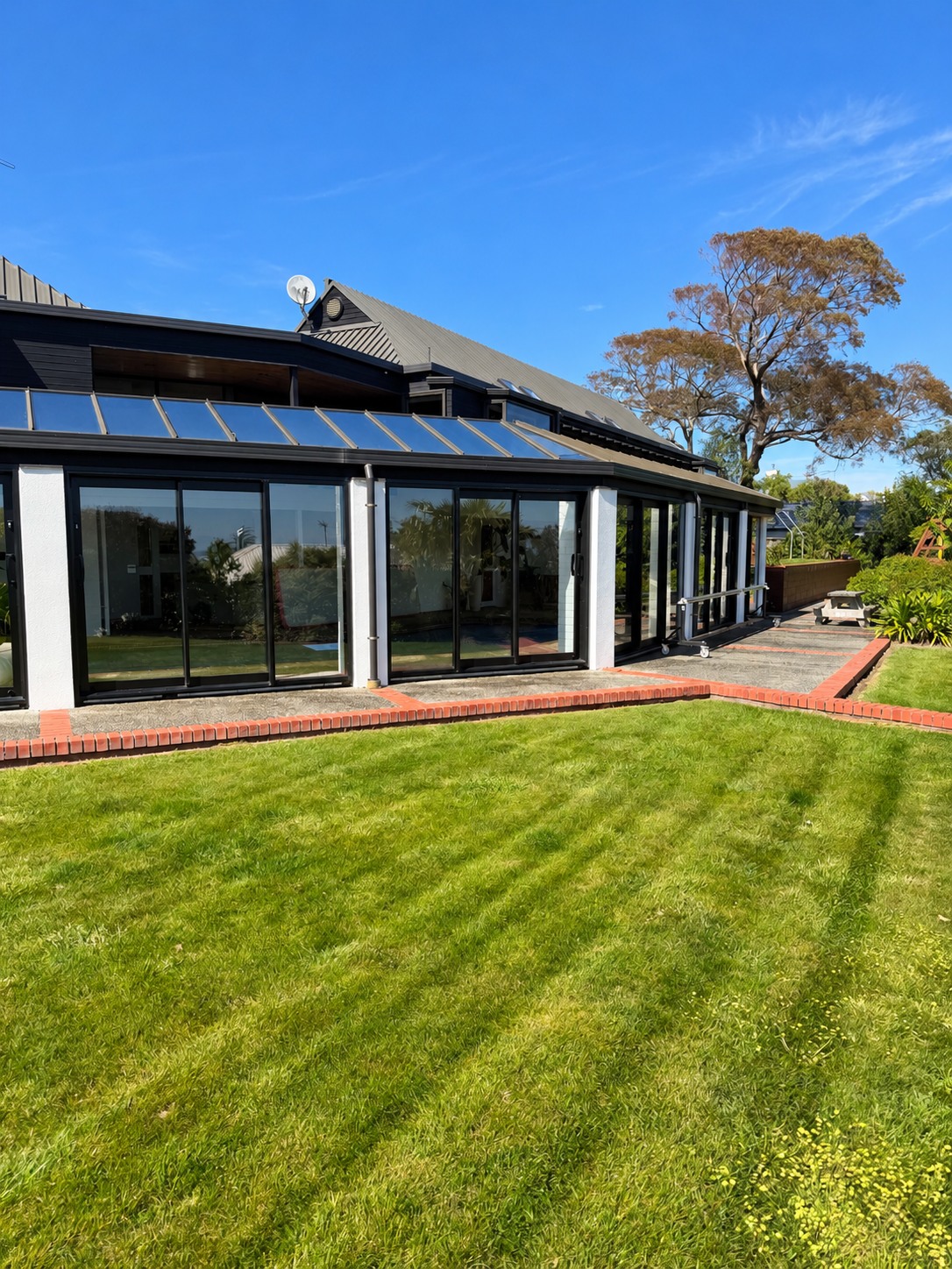Large residential property with extensive glass doors and windows